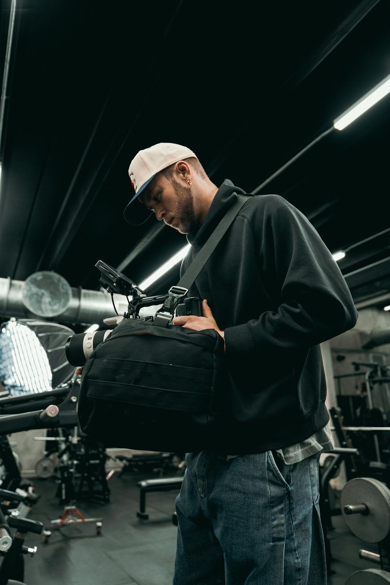 A cinematographer adjusts camera equipment indoors on a film set.